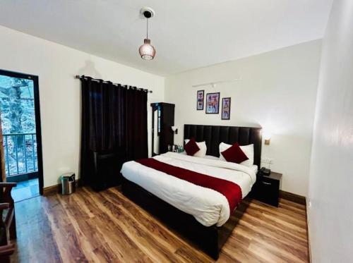 a bedroom with a large bed with red pillows at The Boho Heritage Woods in Nainital