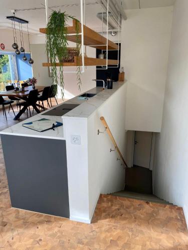 a kitchen with a white counter and a table at 120m2 modern 3-Bedroom Loft in Zürich in Zürich