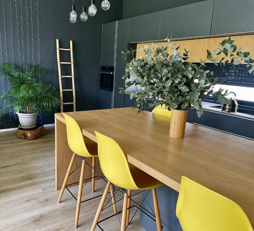 a kitchen with a wooden table and yellow chairs at 4 Lulworth in Johannesburg