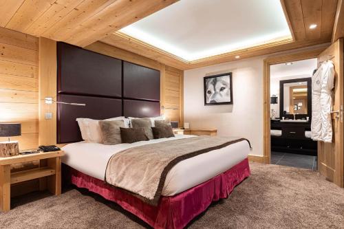 a bedroom with a large bed with a large headboard at Le Kaïla in Méribel