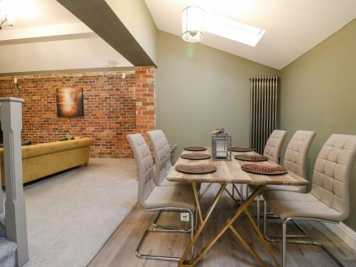 a dining room with a wooden table and chairs at Hunters Lodge at Wildersley Farm in Belper