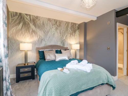 a bedroom with a bed with towels on it at Hunters Lodge at Wildersley Farm in Belper