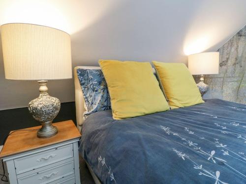 a bedroom with a bed and a lamp on a nightstand at Hunters Lodge at Wildersley Farm in Belper