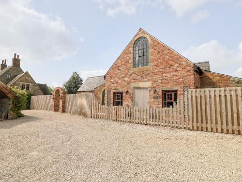 an old brick church with a wooden fence at Hunters Lodge at Wildersley Farm in Belper