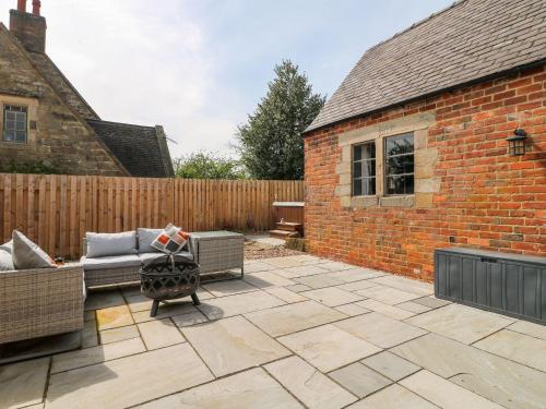 a patio with a couch and a fence at Hunters Lodge at Wildersley Farm in Belper