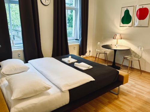 a bedroom with a bed with two pillows and a table at VELVET apartment in Weimar