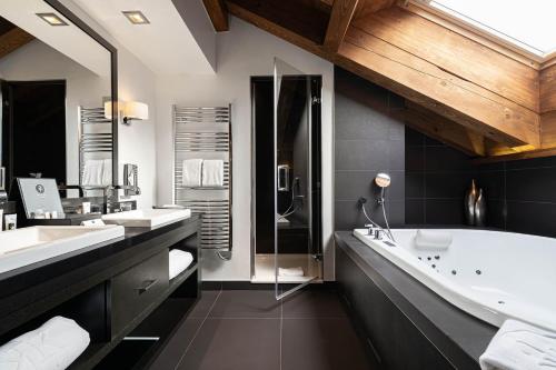 a bathroom with two sinks and a bath tub at Le Kaïla in Méribel