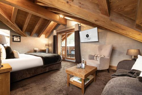 a hotel room with a large bed and a chair at Le Kaïla in Méribel
