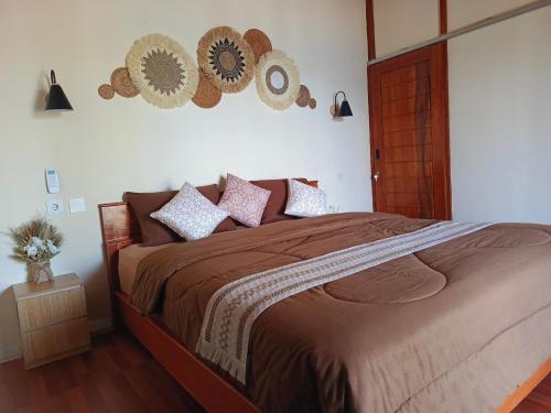 a bedroom with a bed with pillows and hats on the wall at Yellow Coco Gili Gede in Gili Gede