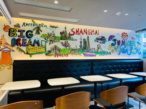 a dining room with tables and a big dream mural at Dayin Garden Hotel -People's Square & Nanjing Road-Large Social Area -Bar -Café -Gym -Free Laundry Luggage Storage -24H Front Desk-English Service in Shanghai