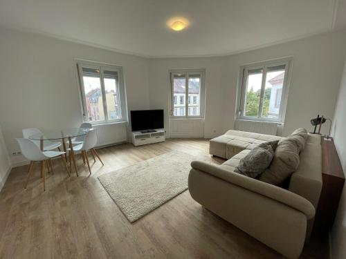 a living room with a couch and a table at Mulhouse, Urban Family Nest in Mulhouse