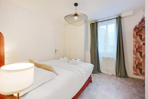 une chambre avec un lit et une grande fenêtre dans l'établissement Cosy apartment - 1BDR-4P - Boulogne Billancourt, à Boulogne-Billancourt