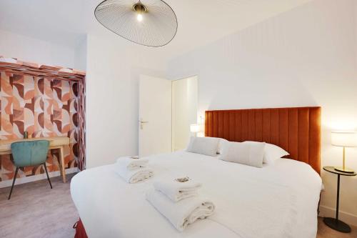 une chambre avec un grand lit blanc avec des serviettes dessus dans l'établissement Cosy apartment - 1BDR-4P - Boulogne Billancourt, à Boulogne-Billancourt
