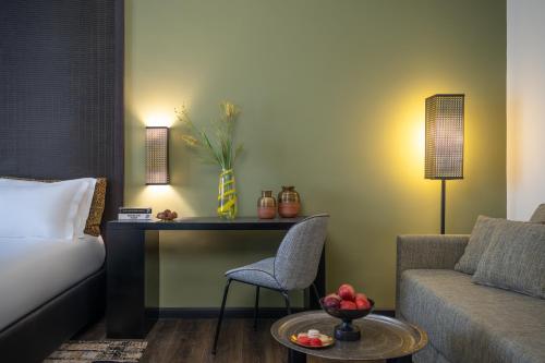 a room with a bed and a desk and a couch at Dan Boutique Hotel Jerusalem in Jerusalem