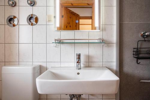 a bathroom with a sink and a toilet and a mirror at Haus Albatros Wohnung 3 in Ostseebad Koserow