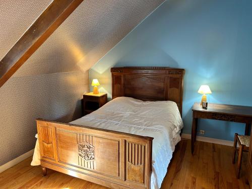 - une chambre avec un lit en bois et 2 tables dans l'établissement 202 - Maison en pierre à proximité des Sables-D'or, à Plurien