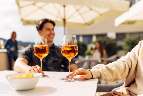 two people sitting at a table with glasses of wine at harry's home Zürich-Limmattal in Spreitenbach
