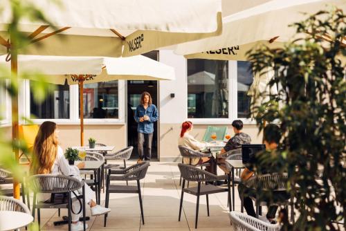 a group of people sitting at tables in a restaurant at harry's home Zürich-Limmattal in Spreitenbach