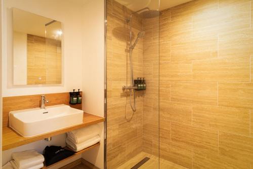 a bathroom with a sink and a shower at voco Beaune , Cité des Vins by IHG in Beaune