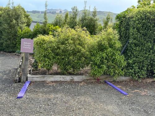 a garden with bushes and a sign in front of it at Kūkupa Taunga at Akaroa Lavender by Tiny Away in Akaroa