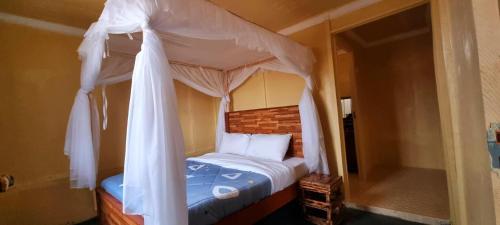 a bedroom with a canopy bed with white curtains at Amanya 2-Bedroom Self Catering Tent in Amboseli