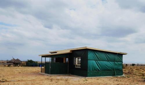 a green building in the middle of a field at Amanya 2-Bedroom Self Catering Tent in Amboseli