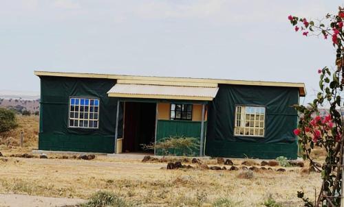 a green house with two windows in a field at Amanya 2-Bedroom Self Catering Tent in Amboseli