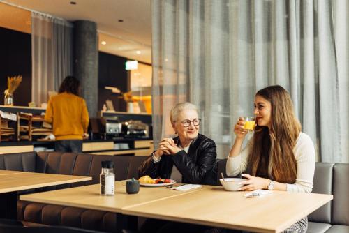 a man and a woman sitting at a table with drinks at harry's home Zürich-Limmattal in Spreitenbach