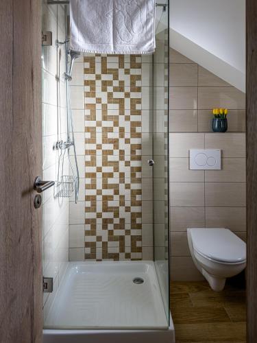 a bathroom with a shower and a toilet and a tub at Penzión Tulipán in Jelka