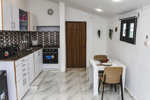 een keuken met witte kasten en een tafel met stoelen bij Appartement 2pièces et terrasse in Abidjan