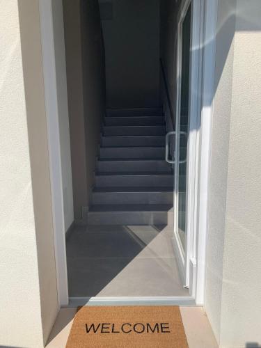 a staircase with a welcome sign in front of a door at Angolo di Paradiso in Mirano