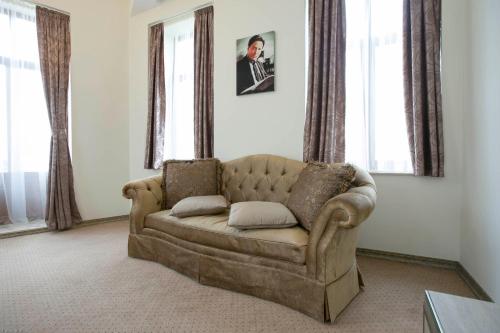 a couch sitting in a living room with windows at Euro Hotel Grivita in Bucharest