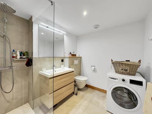 une salle de bain avec une machine à laver et un lave-linge dans l'établissement GRD114 Appartement standing 6 pers pied de piste, aux Carroz d'Arâches