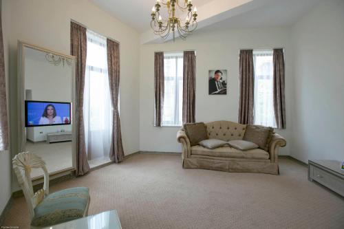 a living room with a couch and a tv at Euro Hotel Grivita in Bucharest