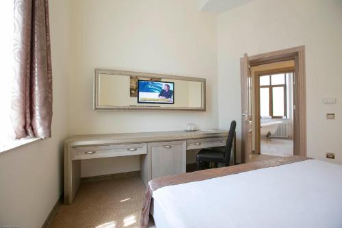 a bedroom with a desk and a mirror and a bed at Euro Hotel Grivita in Bucharest