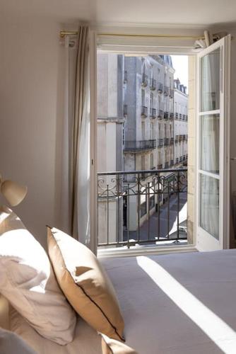 - une chambre avec une fenêtre donnant sur un bâtiment dans l'établissement Charmant 2 pièces ultra-centre au calme, à Nantes