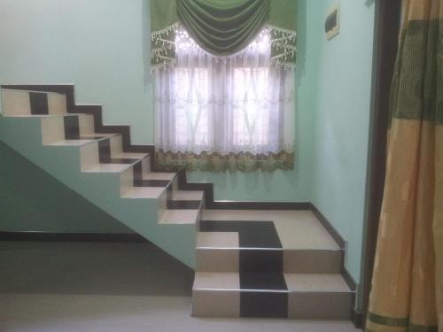 a staircase leading to a window with a curtain at veranda guest home in Mirissa