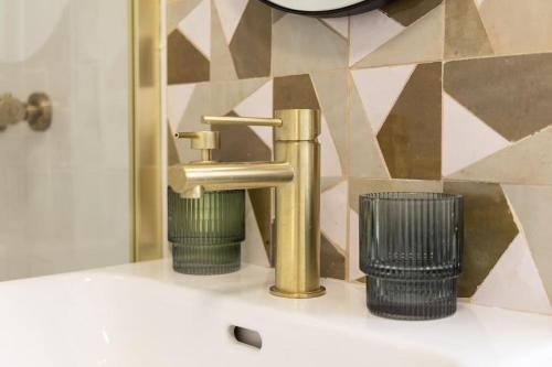 - un lavabo avec un robinet en or et une poubelle dans l'établissement Charmant 2 pièces ultra-centre au calme, à Nantes