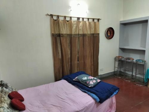 パトナーにあるAhana's Artistic Home Stayのカーテン付きの客室の小さなベッド1台分です。