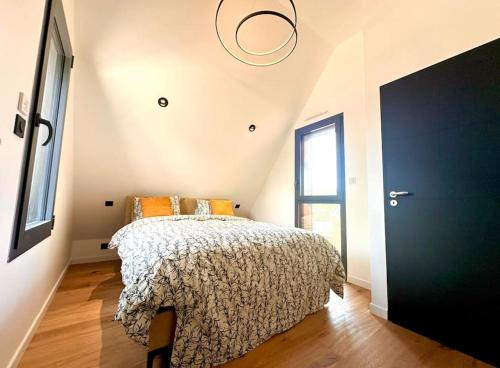 - une chambre avec un lit et une porte noire dans l'établissement Maison neuve - Piscine chauffée - Erdeven, à Erdeven