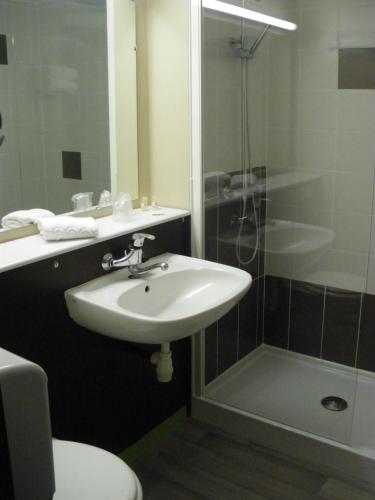 a bathroom with a sink and a shower and a toilet at Initial by balladins Dieppe in Saint-Aubin-sur-Scie