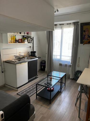 un salon avec une table et une cuisine dans l'établissement Pretty Montmartre, à Paris