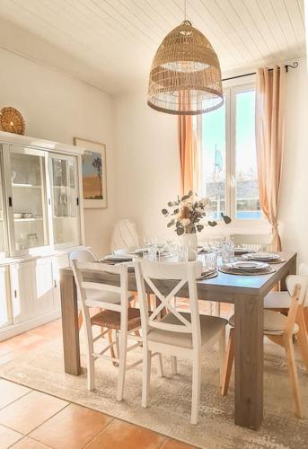 une salle à manger avec une table et des chaises blanches dans l'établissement Villa 4 chambres, à Gujan-Mestras