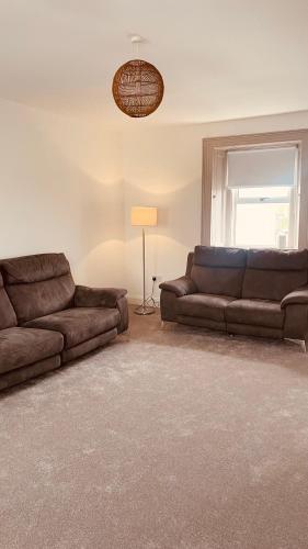 a living room with two brown couches and a window at Colton House - Apt 4 in Tullamore