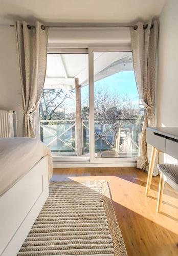 une chambre avec un lit et une grande fenêtre dans l'établissement Villa 4 chambres, à Gujan-Mestras