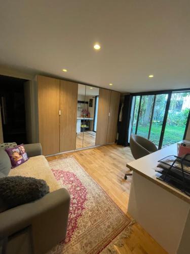 un salon avec un canapé et une table dans l'établissement Chambre Atelier sur jardin, à Antony