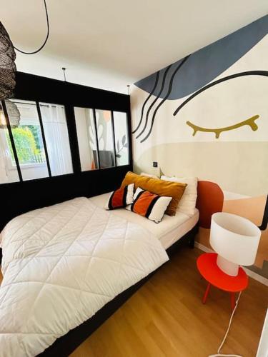 - une chambre avec un lit blanc et un tabouret rouge dans l'établissement Superbe logement au calme, jardin & parking privé, à Concarneau