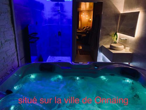 a large tub with blue lighting in a bathroom at Love room in Onnaing