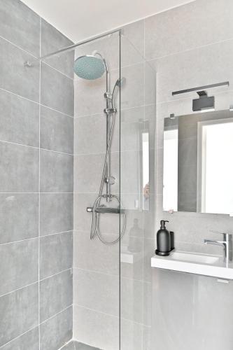 une douche avec une porte vitrée à côté d'un lavabo dans l'établissement Studio confortable Havre de Paix proche Paris - II, à Montreuil