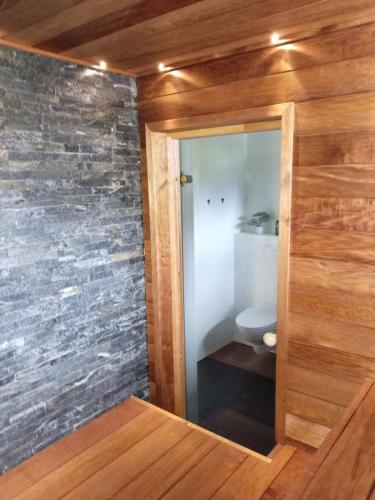 a bathroom with a toilet and a wooden wall at New Heaven in Rovaniemi